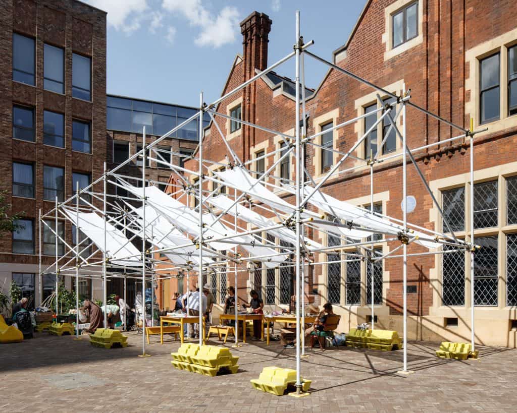 Installation view of On Tenterground by ciaociao design. It features scaffolding and pieces of cloth.